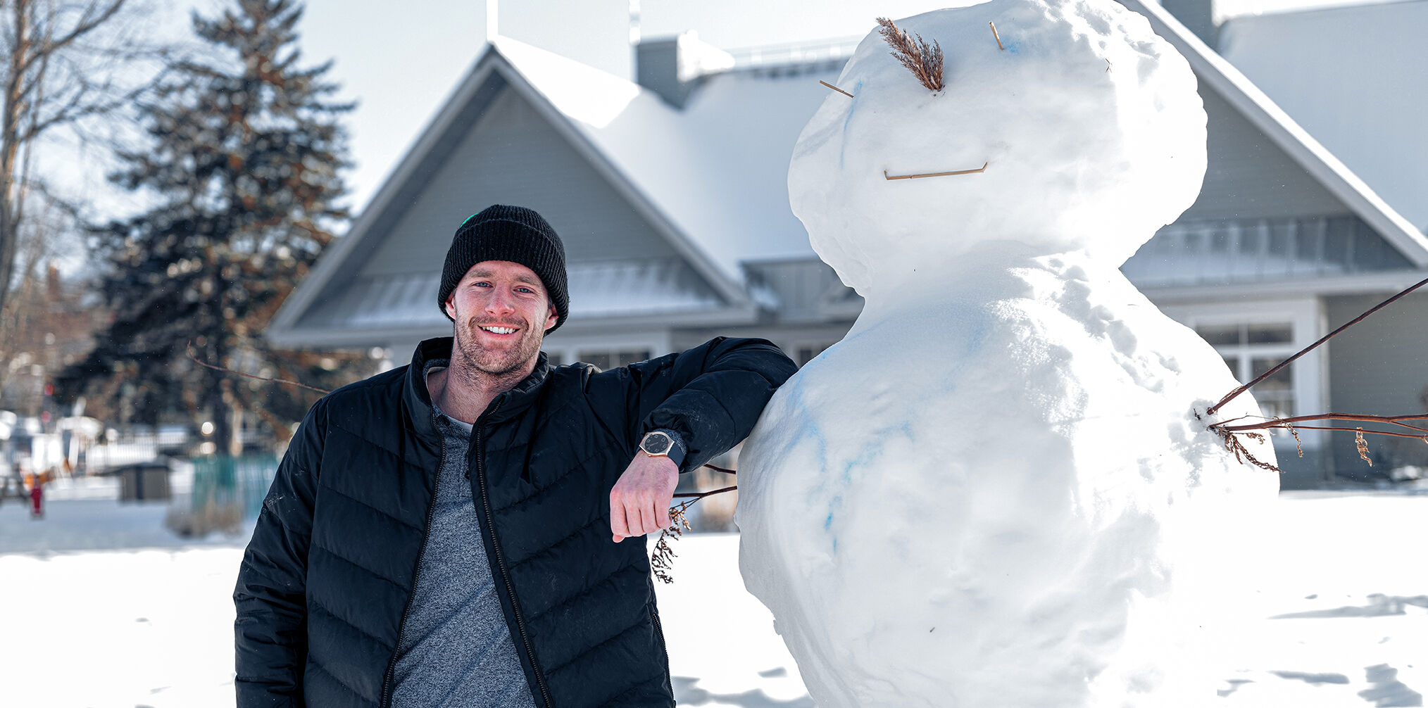 Max Parrot standing next to a snowman